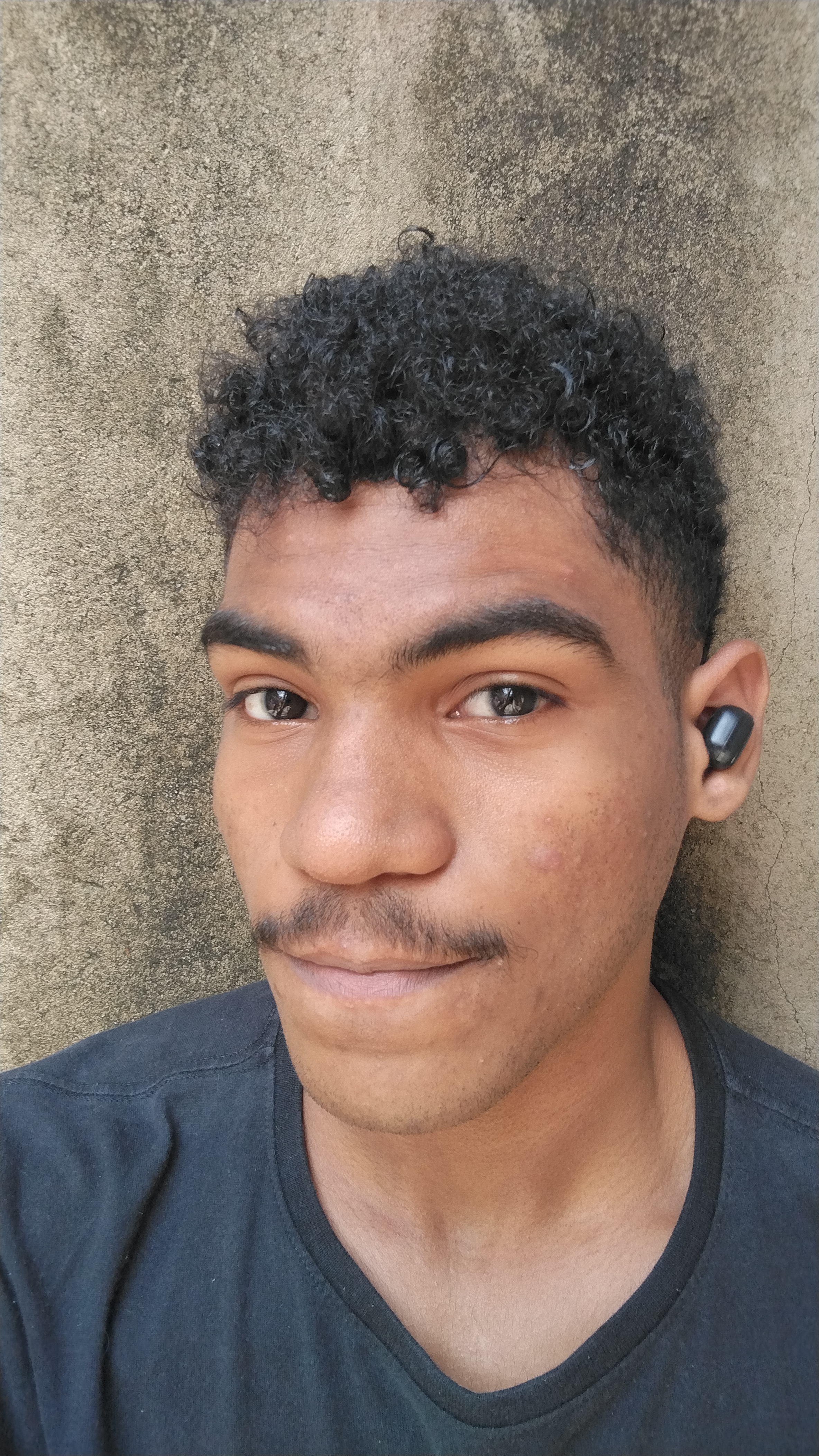 Rosto de um menino negro com cabelo cacheado